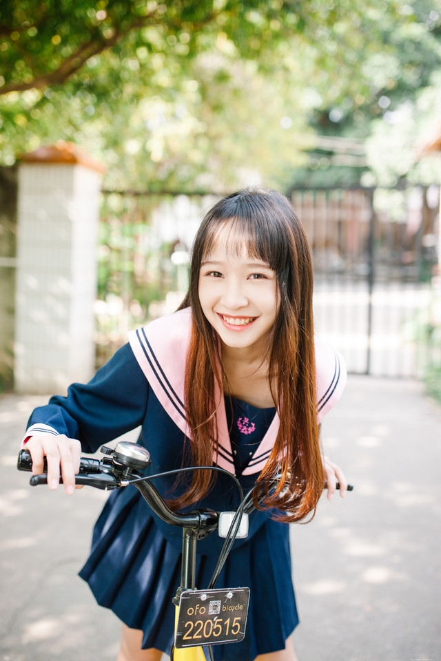 水手服少女俏丽可爱户外骑车满面笑容