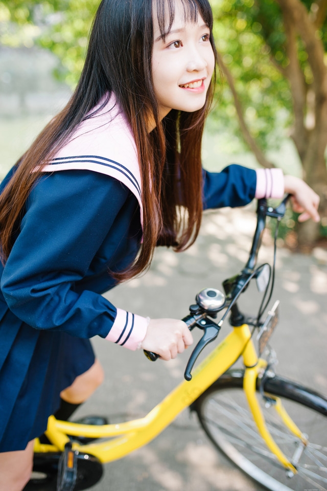 水手服少女俏丽可爱户外骑车满面笑容