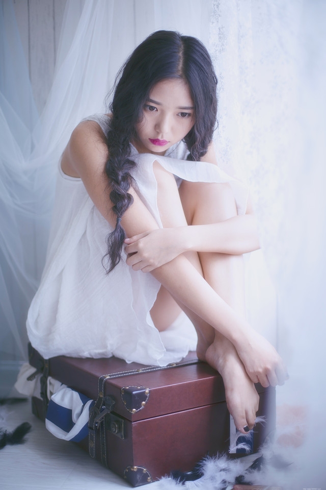 旅行箱内的麻花辫少女眼神忧郁朦胧迷人