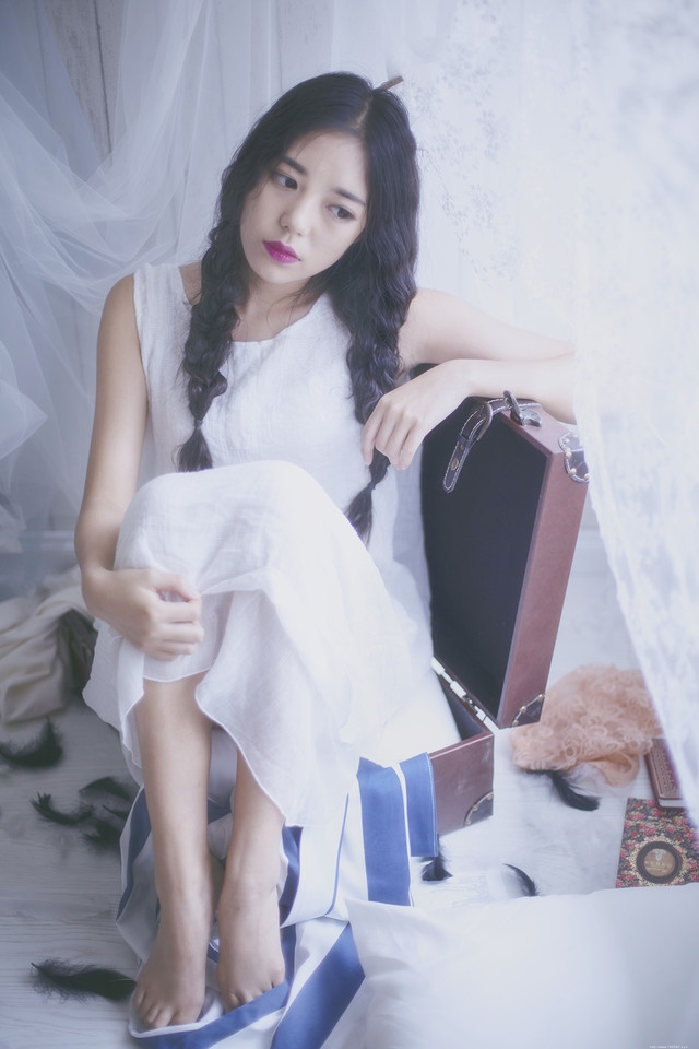 旅行箱内的麻花辫少女眼神忧郁朦胧迷人