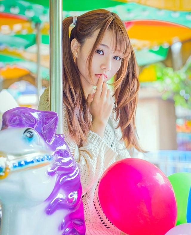 五彩缤纷的游乐场内双马尾少女坐旋转木马