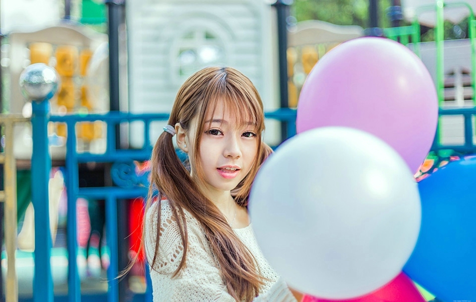 五彩缤纷的游乐场内双马尾少女坐旋转木马