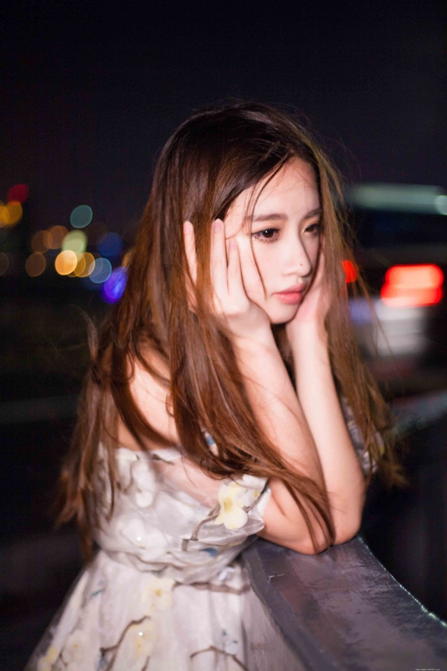 夜晚灯光闪烁下露肩裙美女发型凌乱寂寞写真