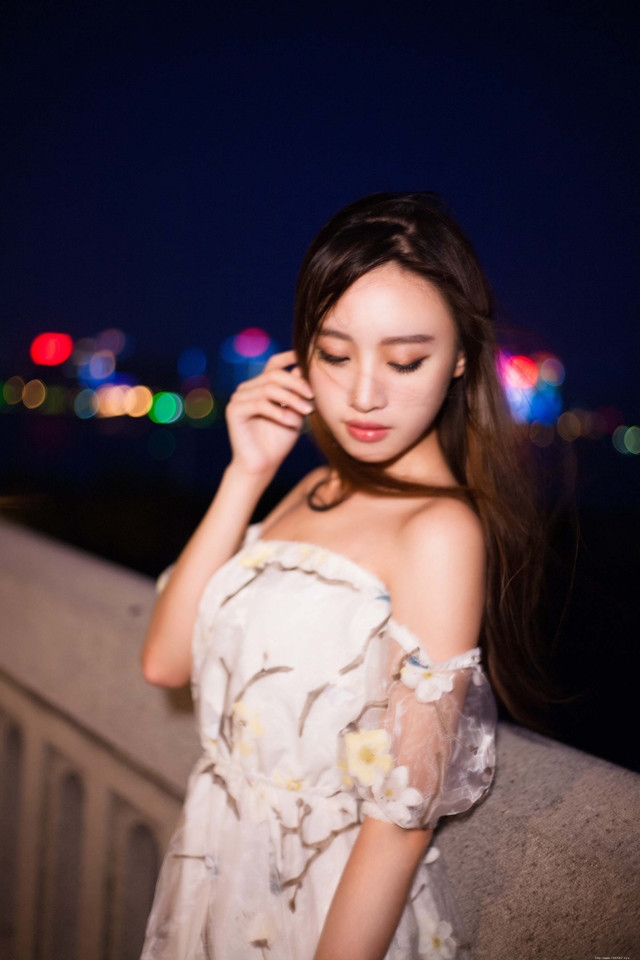 夜晚灯光闪烁下露肩裙美女发型凌乱寂寞写真