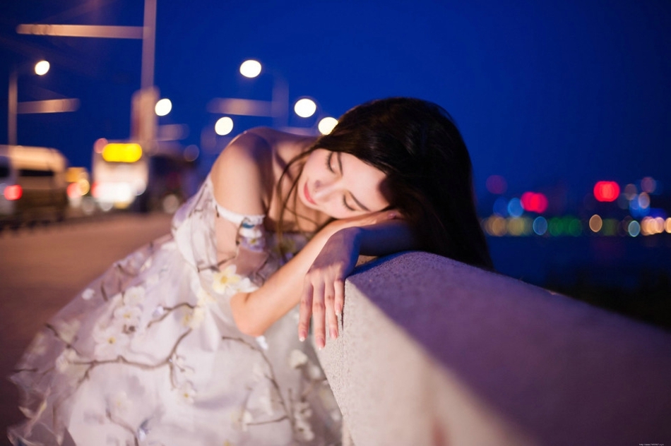 夜晚灯光闪烁下露肩裙美女发型凌乱寂寞写真