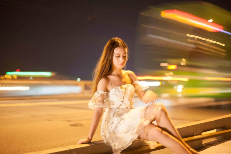 夜晚灯光闪烁下露肩裙美女发型凌乱寂寞写真