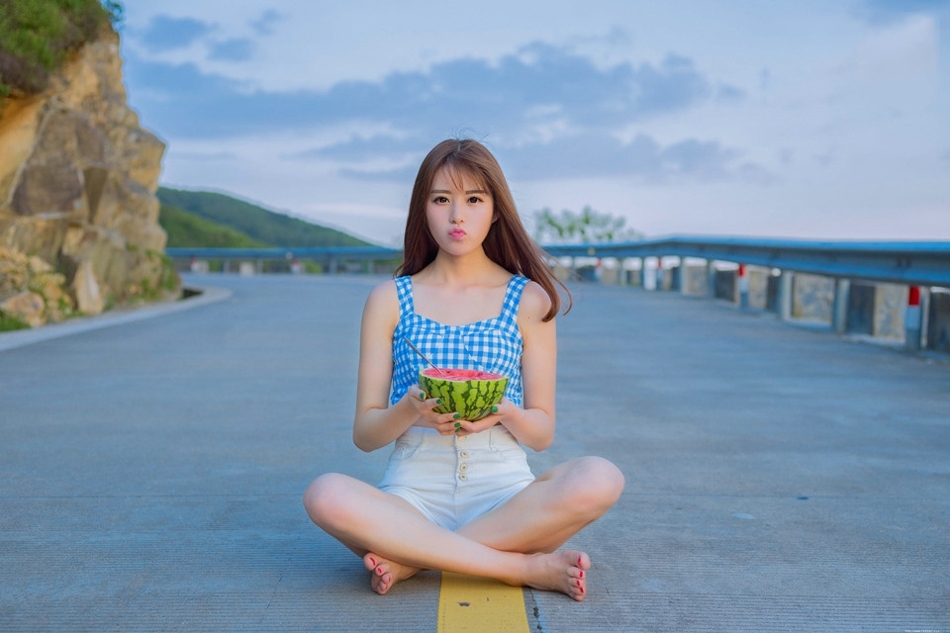 公路上的西瓜少女蓝白格子衫热裤装清凉解暑
