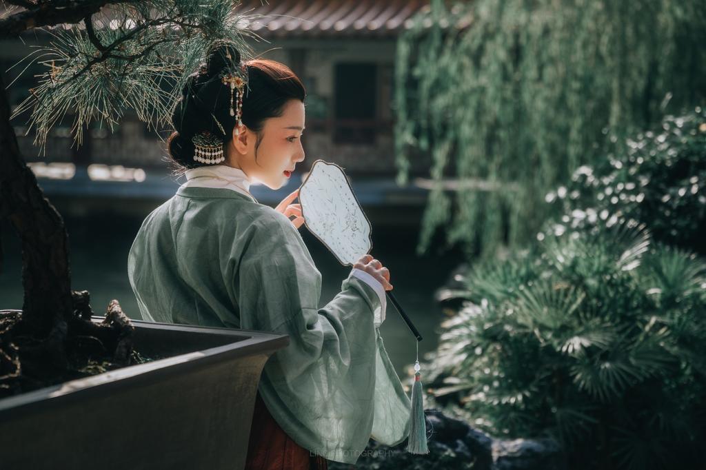 汉服美女手持罗扇漫步园林写真