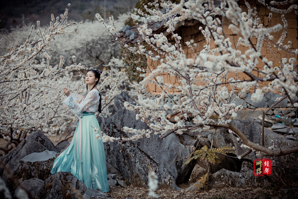 古装美女手执罗扇漫步花林美图