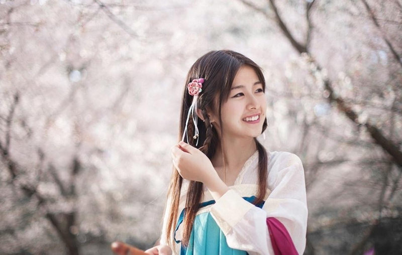 汉服少女桃花树下亭亭玉立图片