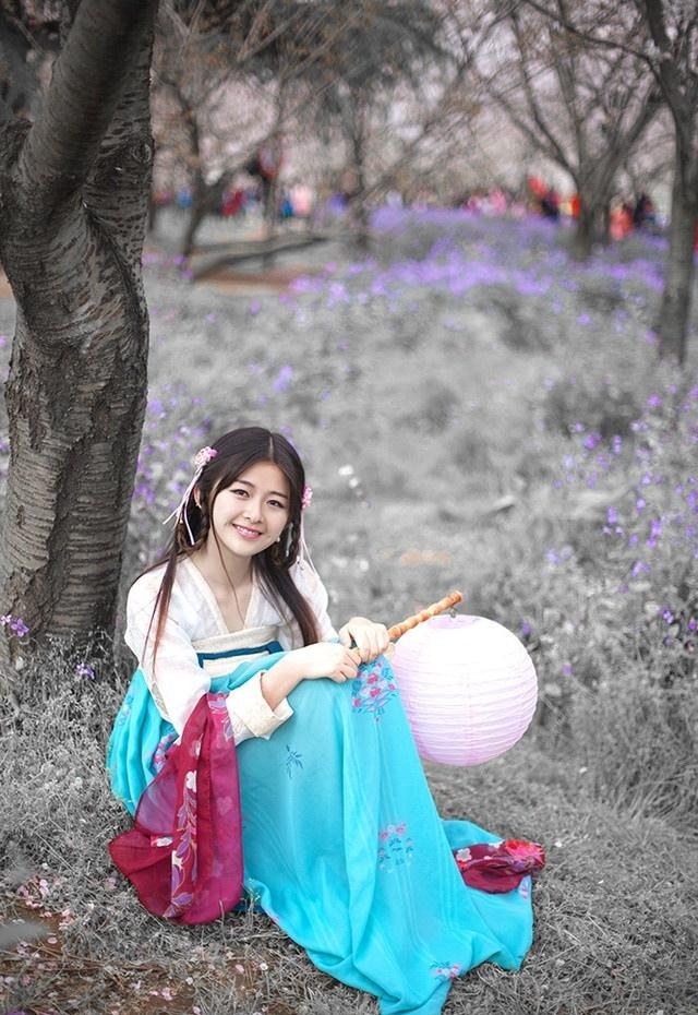 汉服少女桃花树下亭亭玉立图片