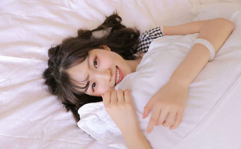 床上美女露齿甜笑清新可人图片