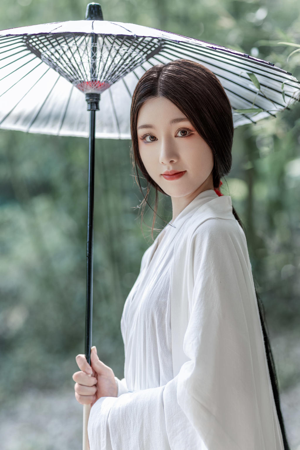撑着油纸伞的白衣美女竹林写真