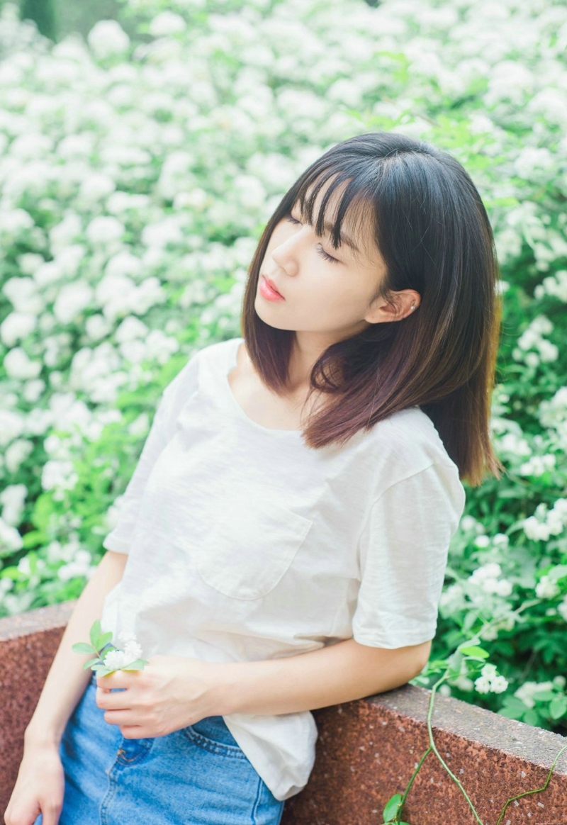 公园花海中的气质白T牛仔裙美女清爽养眼