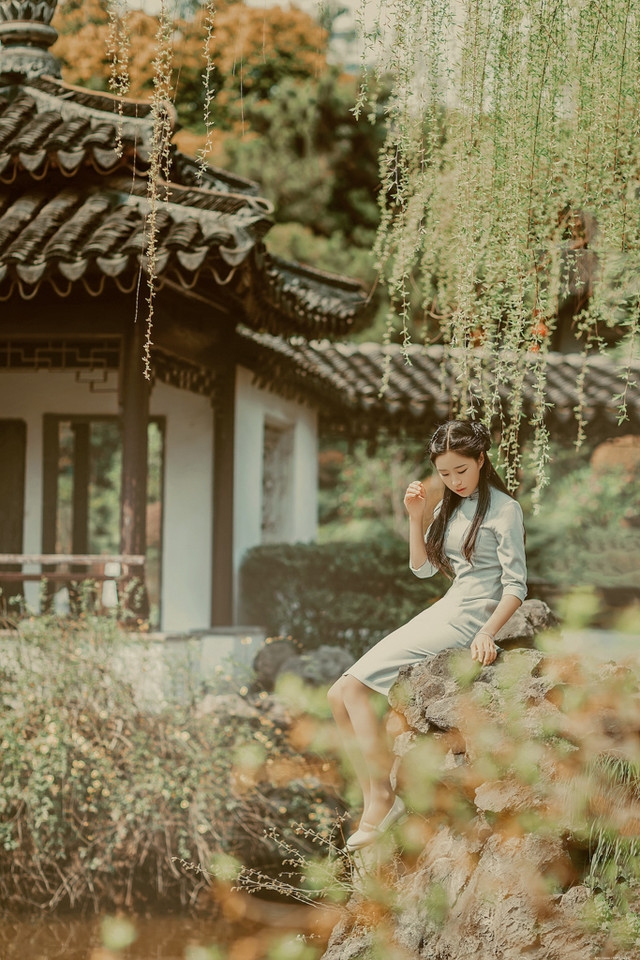 庭院内放风筝的旗袍美女展东方美池边戏水