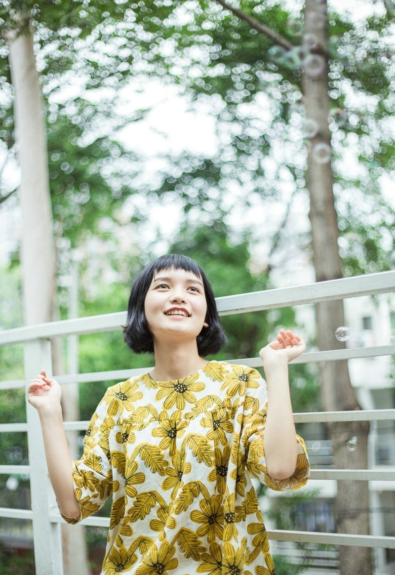 阳光下的短发向日葵妹子与泡泡玩耍