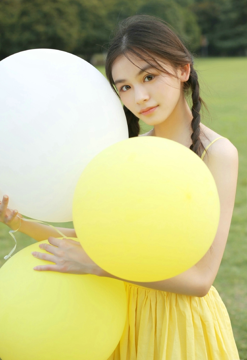 草地上的黄色靓丽连衣裙麻花辫姑娘美丽动人