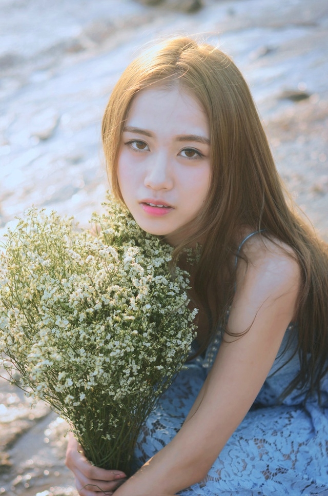 逆光下的海滩美女蓝色蕾丝连衣裙捧花清新