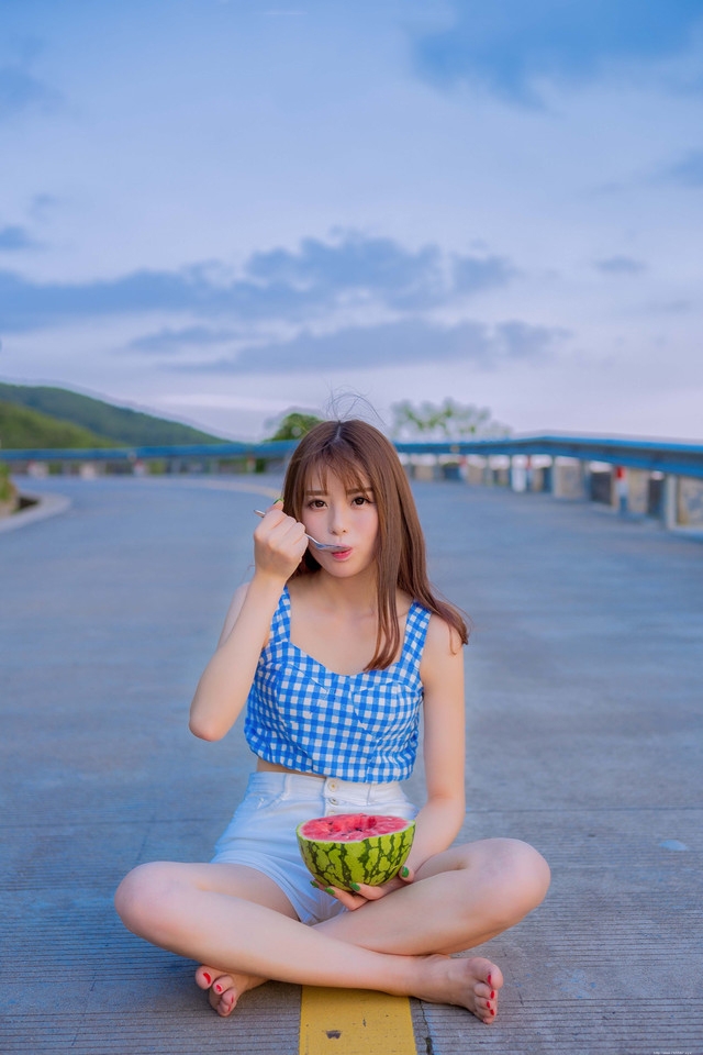 公路上的西瓜少女蓝白格子衫热裤装清凉解暑